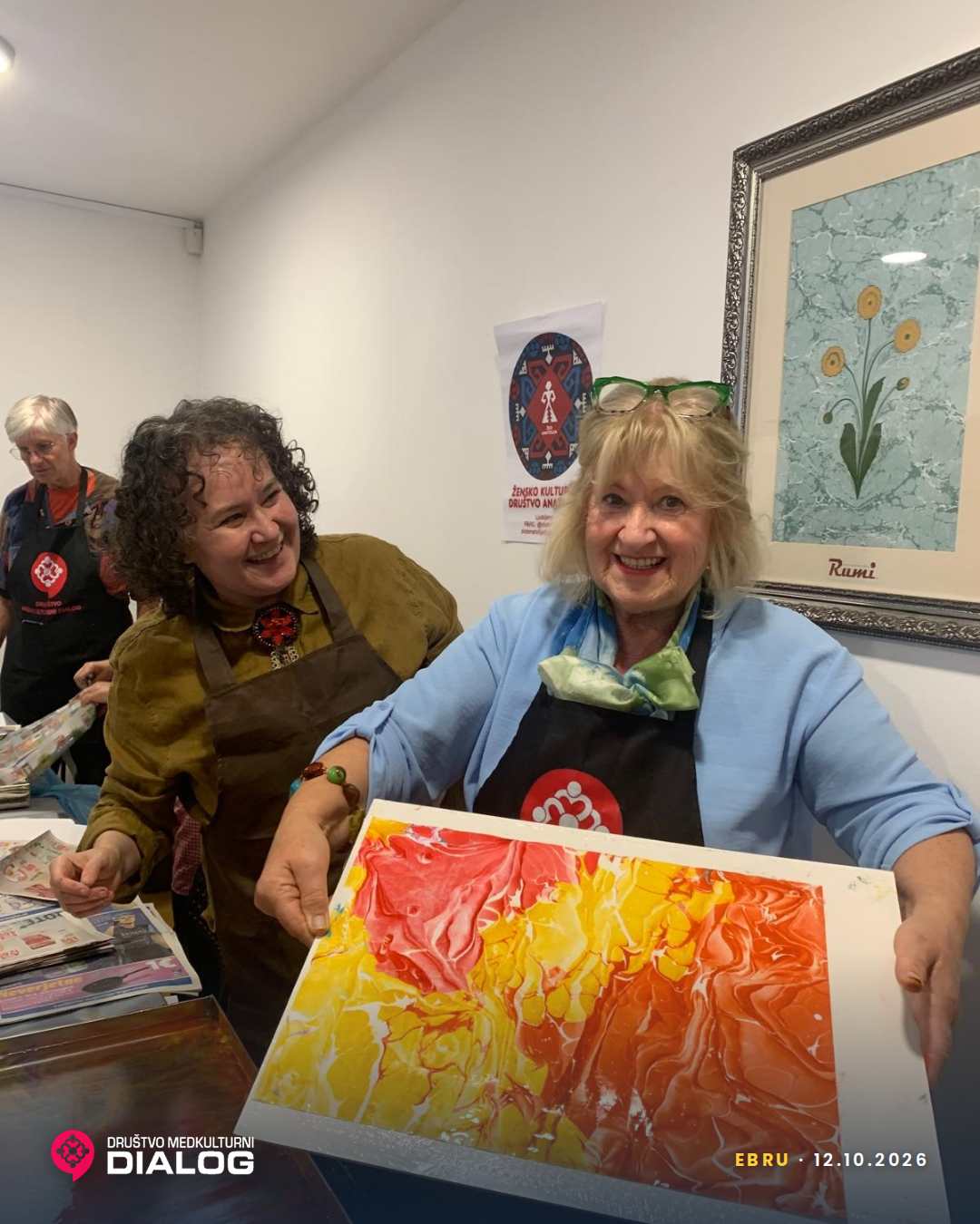 A participant holding a yellow and orange Ebru sheet