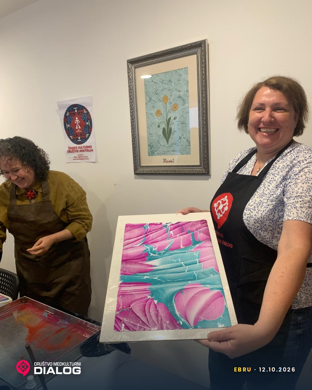 A participant holding a pink and turquoise Ebru sheet